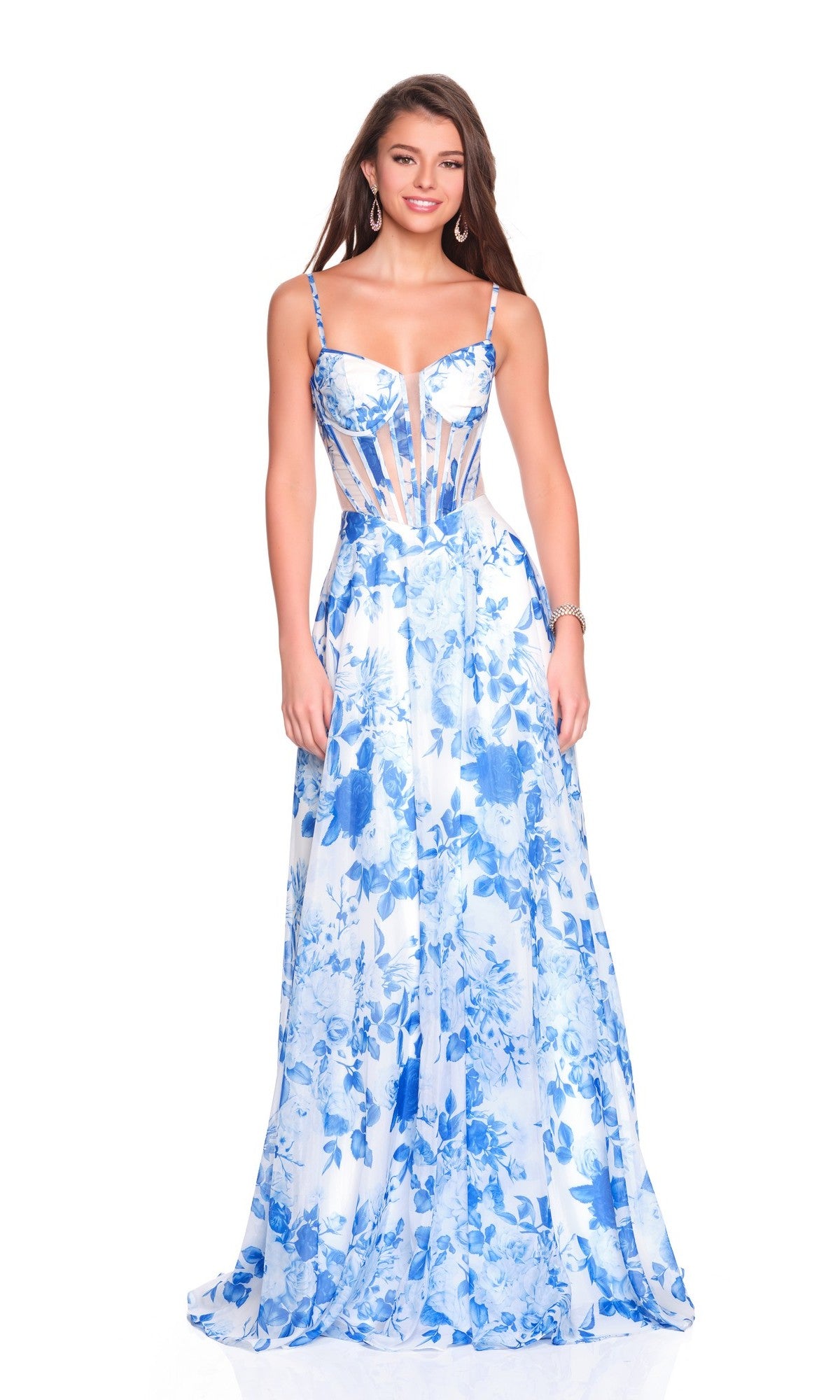 A woman poses and smiles in the Dave & Johnny 12188 Blue Floral Prom Dress, featuring a long, sleeveless design with a fitted corset bodice and sheer panel details against a white background.